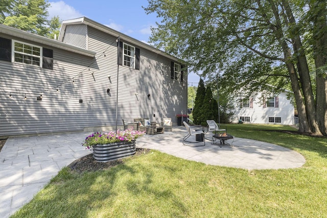 12912 Valley Dr, Wayland, MI 49348 - back of house with a patio area, a lawn, and an outdoor fire pit