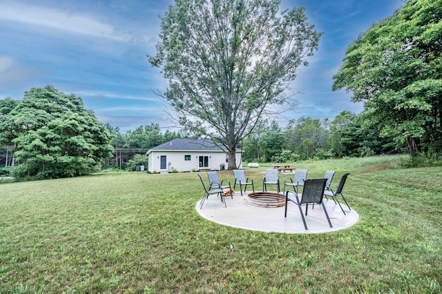 7920 W Juniper Beach Rd, Mears, MI 49436 - view of grassy yard featuring an outdoor fire pit and a patio area