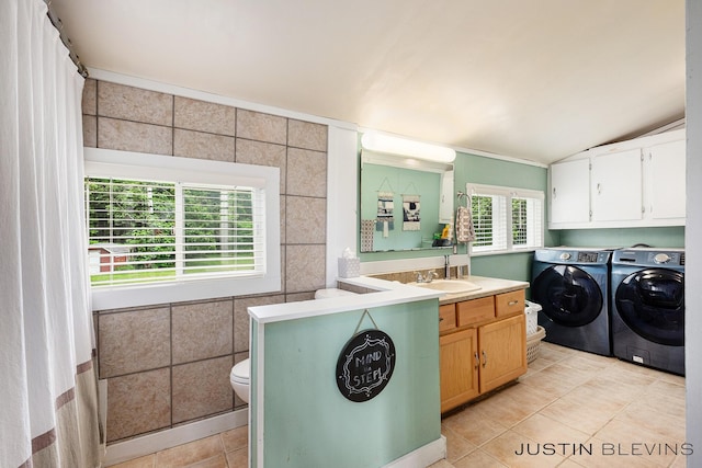 8277 Alpine Ave NW, Sparta, MI 49345 - washroom featuring washing machine and dryer, light tile patterned floors, and tile walls