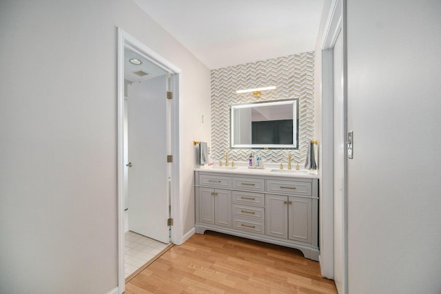 1101 Heritage Dr, Saline, MI 48176 - full bathroom featuring double vanity, wood finished floors, and tasteful backsplash