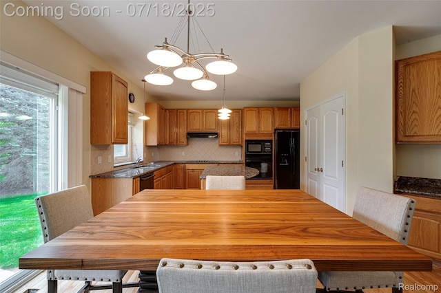 24352 Cavendish Ave W, Novi, MI 48375 - kitchen with tasteful backsplash, black appliances, a center island, pendant lighting, and a chandelier
