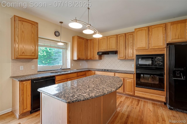 24352 Cavendish Ave W, Novi, MI 48375 - kitchen with black appliances, light wood-style floors, backsplash, and a center island
