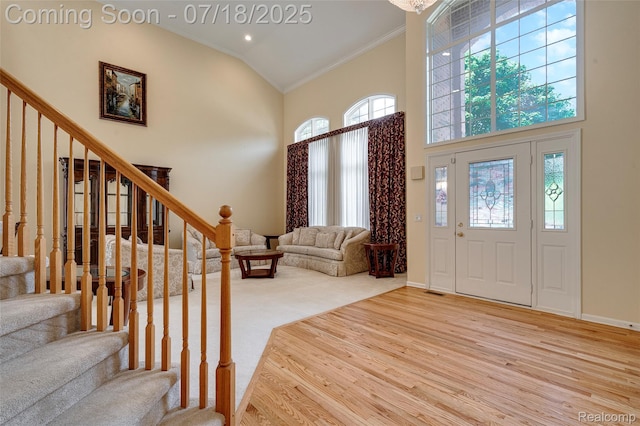 24352 Cavendish Ave W, Novi, MI 48375 - entryway with ornamental molding, high vaulted ceiling, stairs, and wood finished floors