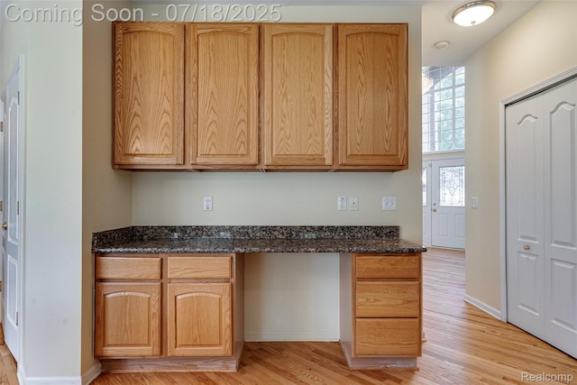 24352 Cavendish Ave W, Novi, MI 48375 - kitchen with built in desk, light wood-style flooring, and dark stone countertops