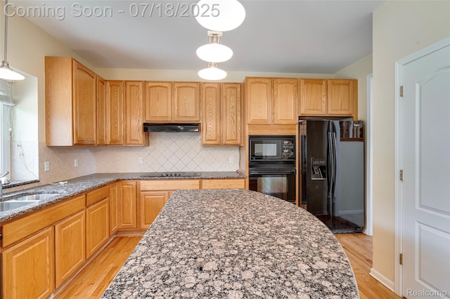 24352 Cavendish Ave W, Novi, MI 48375 - kitchen featuring light wood finished floors, black appliances, dark stone countertops, hanging light fixtures, and decorative backsplash