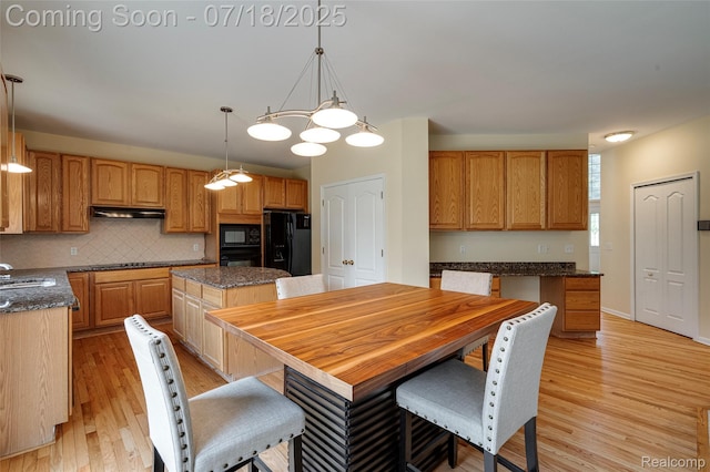 24352 Cavendish Ave W, Novi, MI 48375 - kitchen featuring a kitchen island, light wood-style floors, decorative backsplash, black appliances, and decorative light fixtures