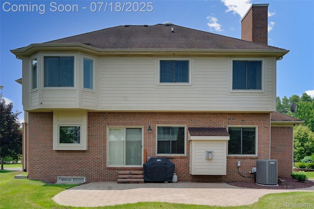 24352 Cavendish Ave W, Novi, MI 48375 - back of property with brick siding, a patio, a chimney, a yard, and entry steps
