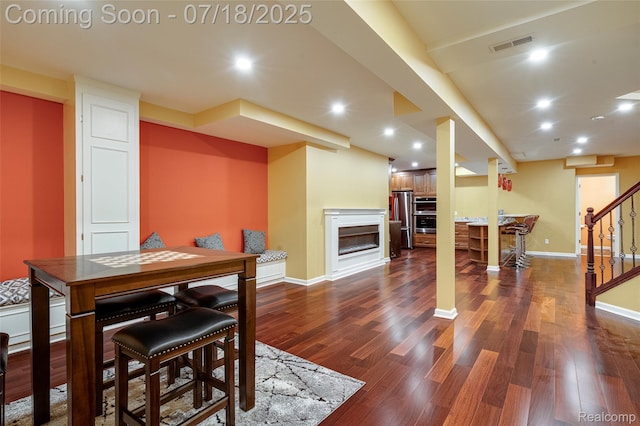 24352 Cavendish Ave W, Novi, MI 48375 - dining room with dark wood-type flooring, stairway, a glass covered fireplace, and recessed lighting