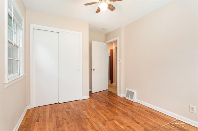 114 E Sugnet Rd, Midland, MI 48642 - unfurnished bedroom with light wood-style floors, a closet, and ceiling fan