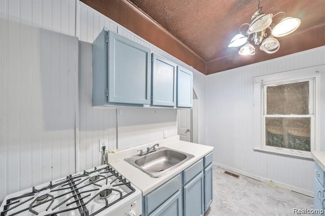 1943 Jarvis Ave, Warren, MI 48091 - kitchen with blue cabinets, white gas range oven, light countertops, wooden walls, and a chandelier