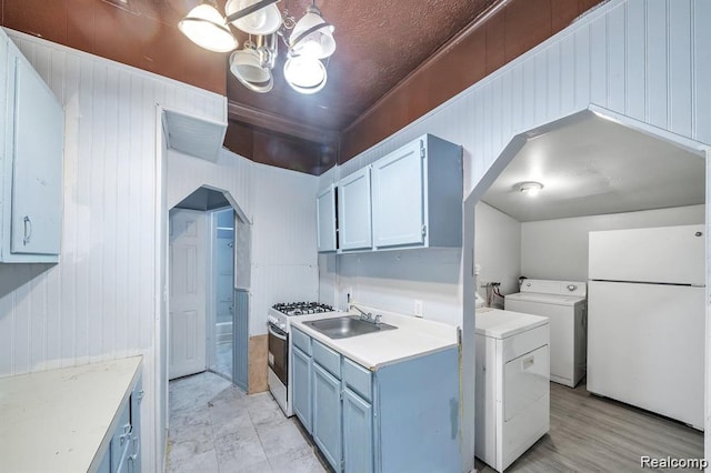 1943 Jarvis Ave, Warren, MI 48091 - kitchen featuring independent washer and dryer, white appliances, light countertops, a chandelier, and blue cabinets