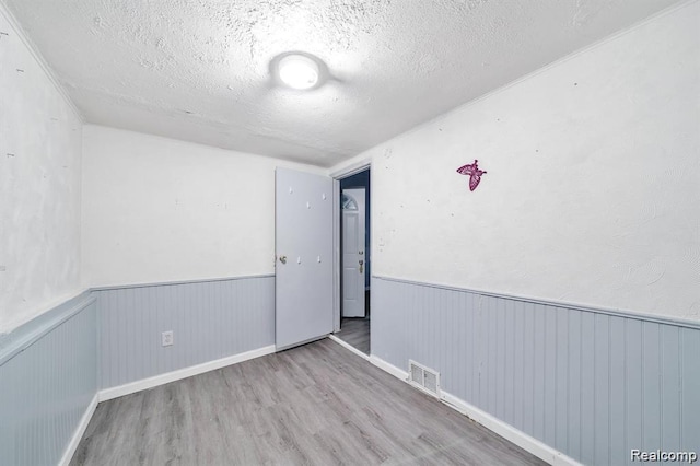 1943 Jarvis Ave, Warren, MI 48091 - spare room featuring wood finished floors, a textured ceiling, and a wainscoted wall