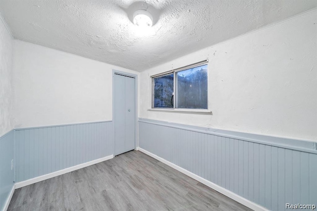 1943 Jarvis Ave, Warren, MI 48091 - spare room with a wainscoted wall, wood finished floors, and a textured ceiling