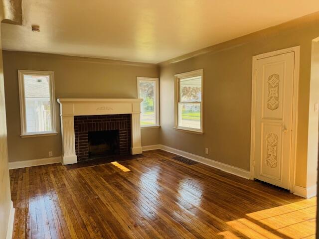 3033 Williams St, Inkster, MI 48141 - unfurnished living room featuring hardwood / wood-style floors and a brick fireplace