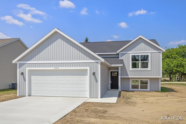 1025 Mechanic St, Big Rapids, MI 49307 - view of front of property featuring a shingled roof, concrete driveway, and a garage