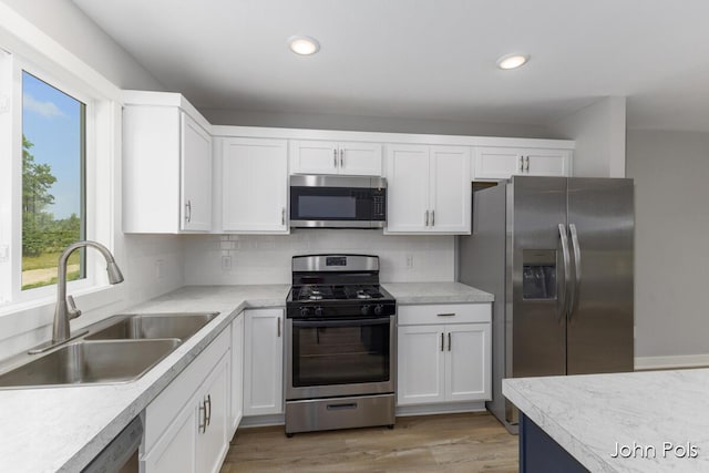 1025 Mechanic St, Big Rapids, MI 49307 - kitchen with appliances with stainless steel finishes, white cabinetry, light countertops, tasteful backsplash, and recessed lighting