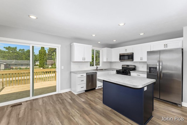 1025 Mechanic St, Big Rapids, MI 49307 - kitchen featuring stainless steel appliances, light countertops, a kitchen island, wood finished floors, and white cabinetry