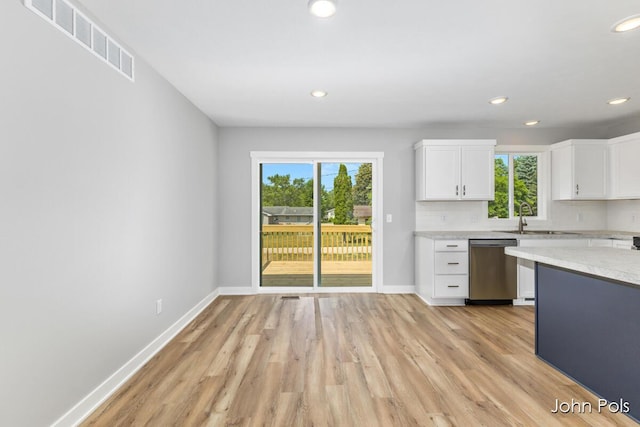 1025 Mechanic St, Big Rapids, MI 49307 - kitchen with light countertops, light wood-style flooring, stainless steel dishwasher, white cabinetry, and recessed lighting