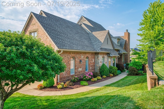 10827 Sparkling Waters Ct, South Lyon, MI 48178 - view of front of house with roof with shingles, brick siding, and a chimney
