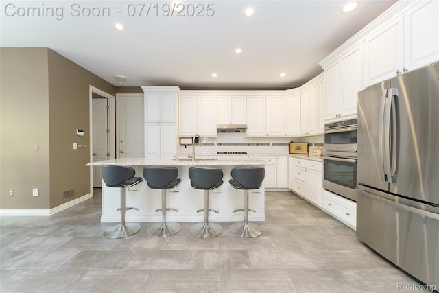 10827 Sparkling Waters Ct, South Lyon, MI 48178 - kitchen with stainless steel appliances, white cabinetry, recessed lighting, light stone countertops, and a kitchen breakfast bar