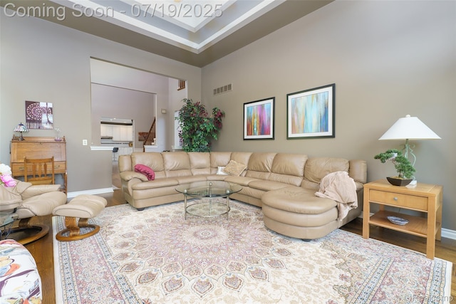10827 Sparkling Waters Ct, South Lyon, MI 48178 - living room featuring wood finished floors, a high ceiling, and stairway