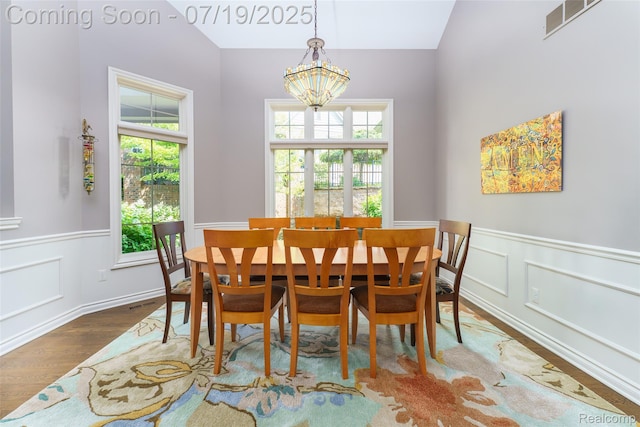 10827 Sparkling Waters Ct, South Lyon, MI 48178 - dining area featuring plenty of natural light, wood finished floors, a wainscoted wall, a chandelier, and vaulted ceiling