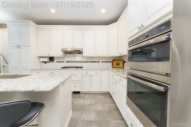 10827 Sparkling Waters Ct, South Lyon, MI 48178 - kitchen featuring stainless steel double oven, white cabinets, backsplash, recessed lighting, and light stone countertops