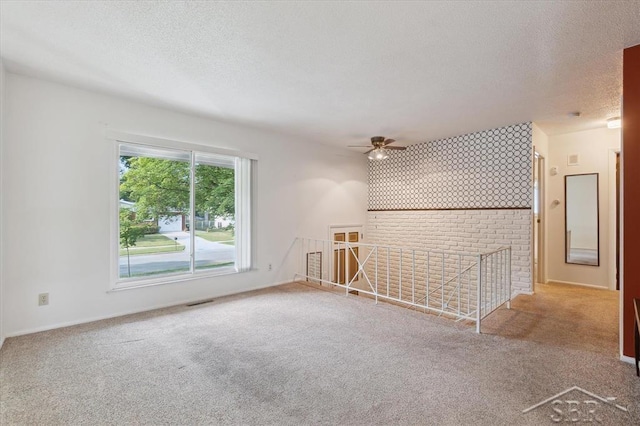 3118 Spruce St, Midland, MI 48640 - unfurnished room featuring a textured ceiling, carpet floors, a ceiling fan, and an accent wall