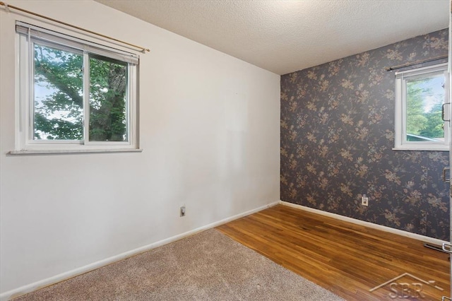 3118 Spruce St, Midland, MI 48640 - empty room with plenty of natural light, wood finished floors, and a textured ceiling