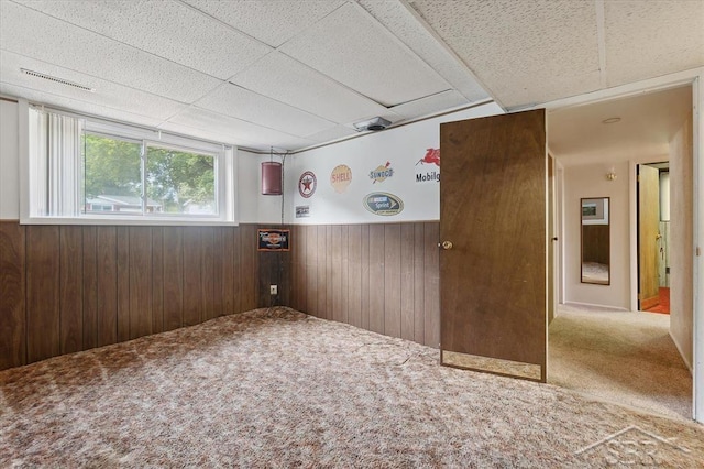 3118 Spruce St, Midland, MI 48640 - spare room featuring carpet, a paneled ceiling, a wainscoted wall, and wood walls