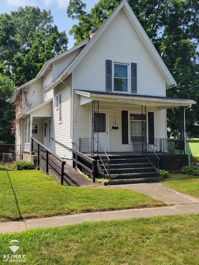 725 River St, Owosso, MI 48867 - view of front facade with a porch, a front yard, and a chimney