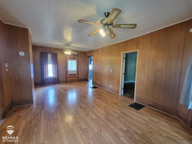 725 River St, Owosso, MI 48867 - spare room with a ceiling fan, wooden walls, and light wood finished floors