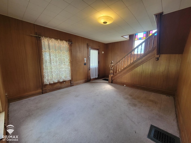 725 River St, Owosso, MI 48867 - carpeted foyer with stairway and wooden walls