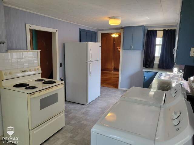 725 River St, Owosso, MI 48867 - kitchen featuring white appliances, blue cabinetry, light floors, light countertops, and washer and clothes dryer