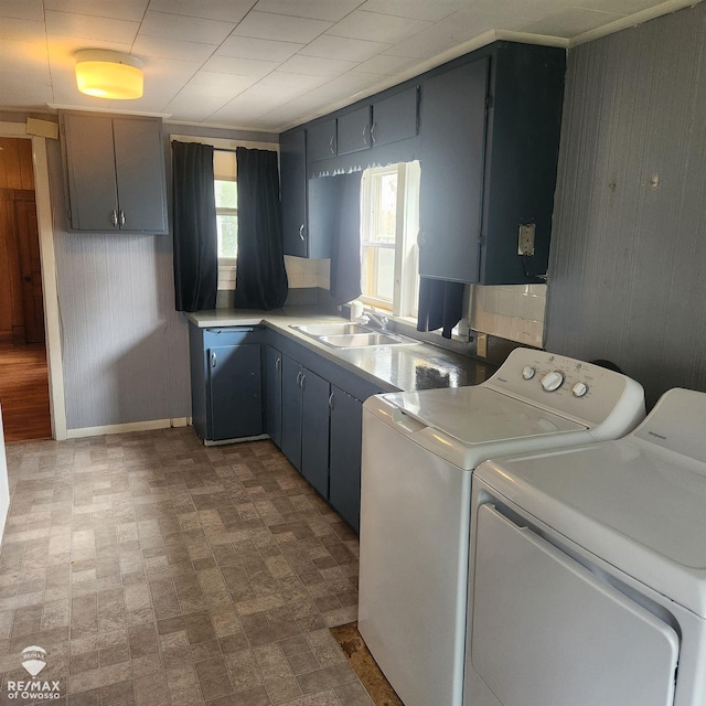 725 River St, Owosso, MI 48867 - laundry room with wooden walls, washer and clothes dryer, and brick patterned floors