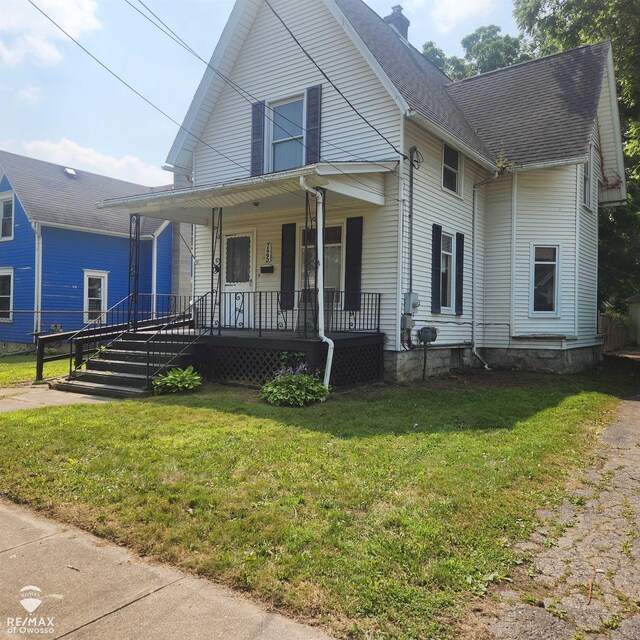 725 River St, Owosso, MI 48867 - view of front of house featuring a porch, a chimney, a front yard, and roof with shingles
