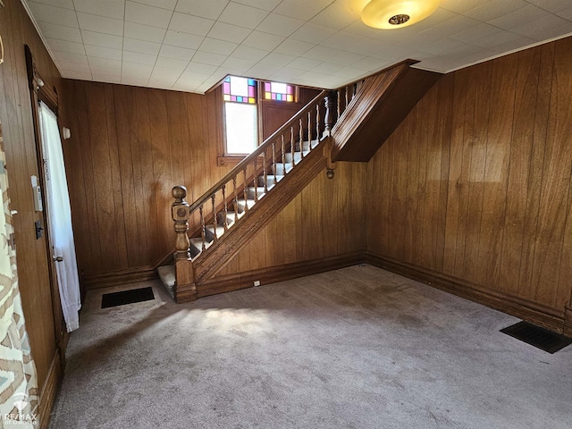 725 River St, Owosso, MI 48867 - carpeted entrance foyer featuring wood walls and stairs