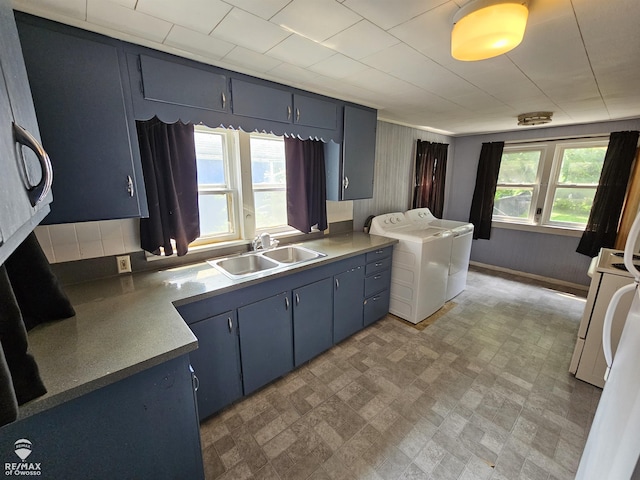 725 River St, Owosso, MI 48867 - kitchen with washer and dryer, brick patterned flooring, blue cabinetry, and stove