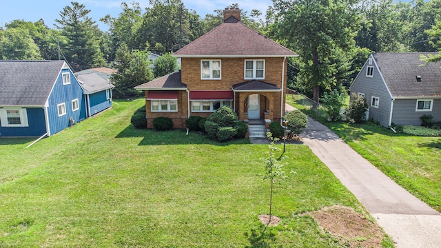 2551 Elmwood Ave, Ann Arbor, MI 48104 - view of front of house with brick siding, concrete driveway, a chimney, a front lawn, and roof with shingles