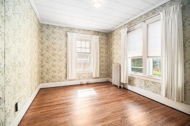 2551 Elmwood Ave, Ann Arbor, MI 48104 - spare room featuring wood finished floors, ornamental molding, wallpapered walls, and radiator heating unit
