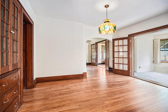 2551 Elmwood Ave, Ann Arbor, MI 48104 - unfurnished room with arched walkways, light wood-style flooring, and french doors