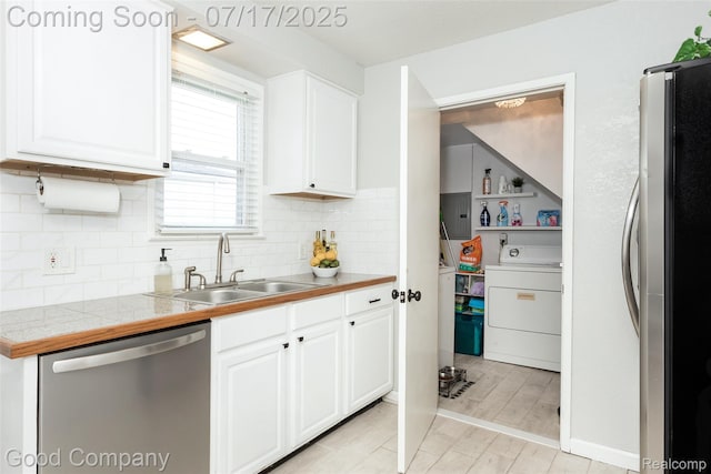 2404 Rowland Ave, Royal Oak, MI 48067 - kitchen featuring washer / clothes dryer, appliances with stainless steel finishes, white cabinetry, and decorative backsplash