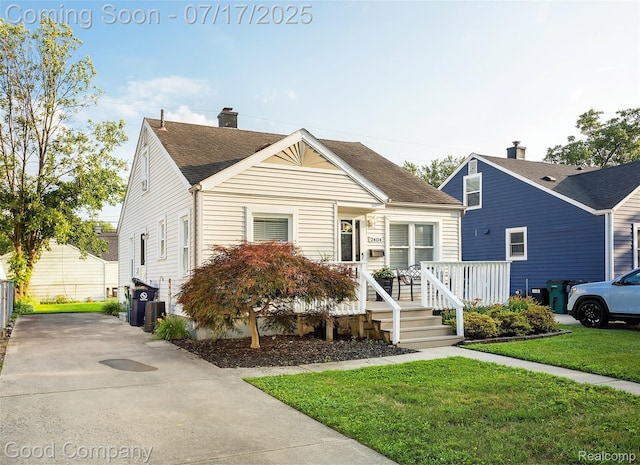2404 Rowland Ave, Royal Oak, MI 48067 - view of front facade featuring covered porch, roof with shingles, a front yard, and concrete driveway
