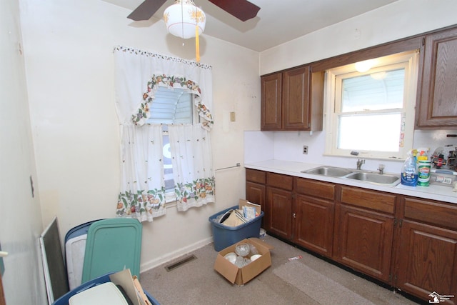 15439 Keegan Rd, Monroe, MI 48161 - kitchen with ceiling fan, light countertops, light colored carpet, and brown cabinetry