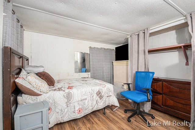 bedroom featuring wood finished floors and a textured ceiling
