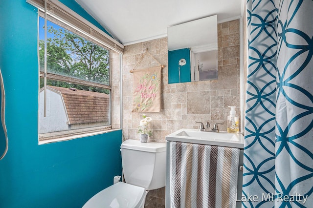 full bathroom featuring vaulted ceiling, vanity, tile walls, and a shower with shower curtain