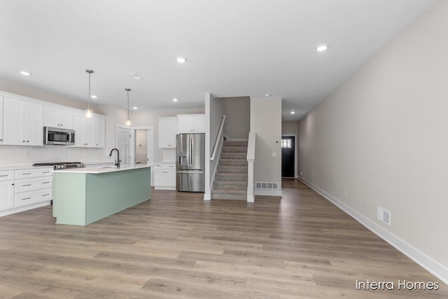 3349 Kings River St SW Unit 36, Wyoming, MI 49418 - kitchen featuring appliances with stainless steel finishes, recessed lighting, white cabinets, decorative backsplash, and light wood-style floors