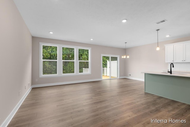 3349 Kings River St SW Unit 36, Wyoming, MI 49418 - unfurnished living room featuring a chandelier, wood finished floors, and recessed lighting