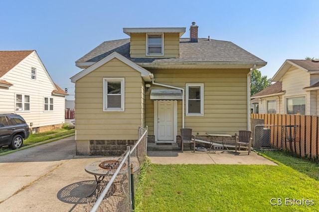 45 Murray St SW, Grand Rapids, MI 49548 - rear view of property with a shingled roof, a chimney, and a patio