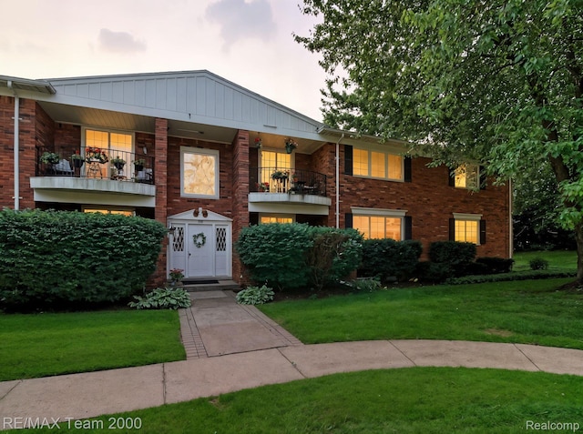 1711 Huntingwood Ln, Bloomfield Hills, MI 48304 - view of front of home featuring a balcony, a front yard, brick siding, and board and batten siding